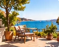 Terrasse avec fauteuils face à la mer.