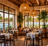 Salle du restaurant aux grandes baies vitrées, suspensions en osier.